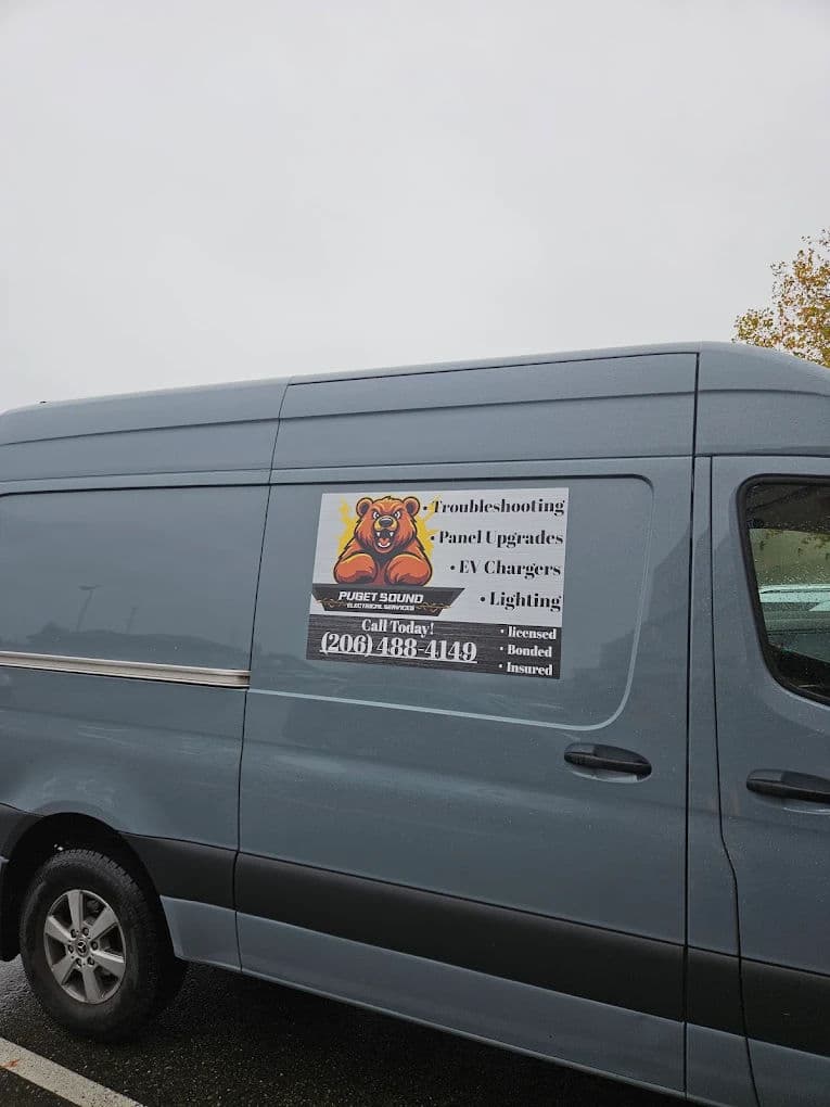 Gray work van with a bear logo and services for troubleshooting, EV chargers, and lighting.
