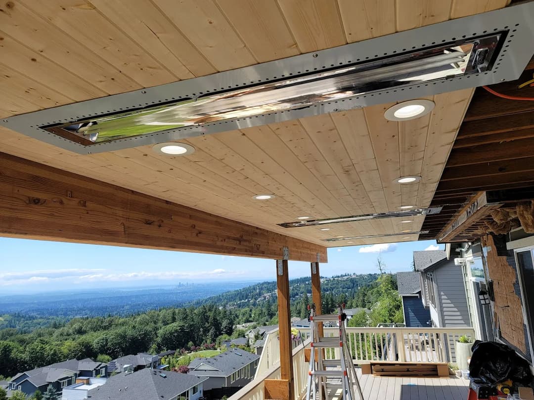 Modern outdoor patio with infrared heaters and recessed lighting overlooking a scenic view.